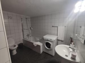a bathroom with a washing machine and a sink at Casa das Hortênsias in Horta