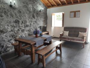 a dining room with a table and a bench at Casa das Hortênsias in Horta