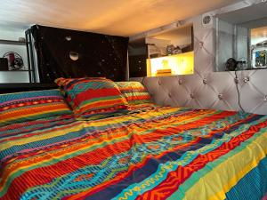 a bed with a colorful comforter and two pillows at Magnifique studio au coeur du Marais in Paris