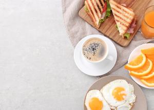 a plate of food with a sandwich and a cup of coffee at Frankstay By Hotel Preet in 05 mints walking Distance Nizamuddin Railway Station in New Delhi