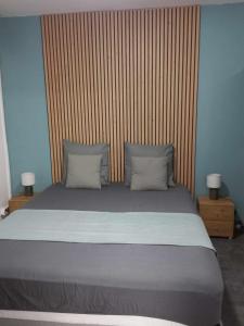 a bedroom with a large bed with a wooden headboard at Corail Azur Terre Sainte in Saint-Pierre