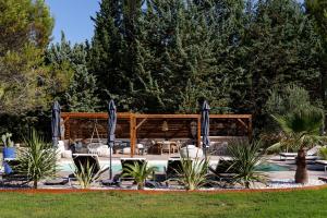 una piscina con mesa, sillas y árboles en LES LODGES TAIZEN, séjour SPA- sans enfants en Saint-Cannat