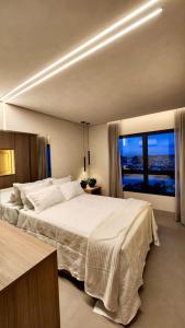 una camera con un grande letto e una grande finestra di Loft Amplo e Aconchegante c/ Quarto Privativo a Campo Grande