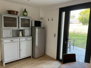 una cucina con frigorifero e una porta che conduce a un cortile. di Gîte à 3 minutes à pied de la mer a Bernières-sur-Mer