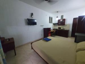 a room with a bed and a tv on the wall at Horton Studios in Colombo