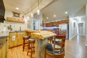 uma cozinha com armários de madeira e um balcão com bancos de bar em Laramie Vacation Rental about 4 Mi to Downtown! em Laramie