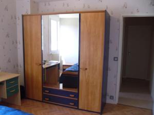 einen großen Holzschrank mit einem Spiegel im Schlafzimmer in der Unterkunft La Saléve in Agen
