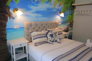 um quarto com uma cama com uma pintura do oceano em PH in Aroeira Lisbon - Beach & Golf em Aroeira