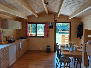 a kitchen and dining room of a log cabin at Autokemp / Speleocamp Malužiná in Malužiná