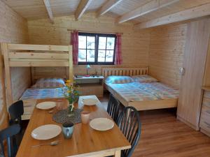 a room with a table and two bunk beds at Autokemp / Speleocamp Malužiná in Malužiná