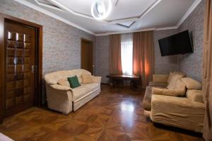 a living room with two chairs and a flat screen tv at Hotel Smile in K'obulet'i
