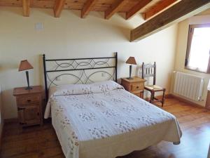 1 dormitorio con 1 cama, 2 mesas y una ventana en La Casona Medieval, en Malillos