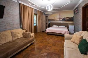 a living room with a couch and a bed at Hotel Smile in K'obulet'i
