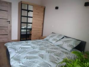 een slaapkamer met een bed en een houten deur bij Uniejów Apartament in Uniejow