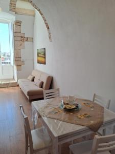 uma sala de estar com uma mesa e um sofá em A Levante em Putignano