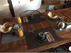 a wooden table with food and drinks on it at La Vignalié in Orban