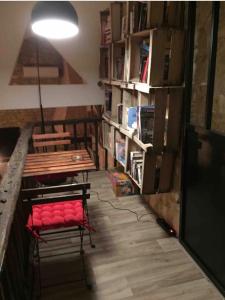 a room with a table and a bench and book shelves at La Vignalié 