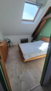 ein Schlafzimmer mit einem Bett und einem Dachfenster in der Unterkunft Maison proche Zoo de Beauval in Poulaines