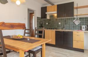 a kitchen with a table with a bowl of fruit on it at Nad tunelom apartment Bohinj in Bohinj