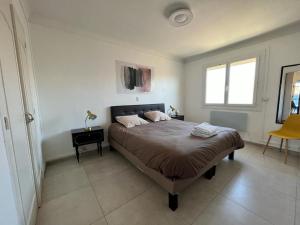 - une chambre avec un lit, une table et une fenêtre dans l'établissement Roussillon appart avec terrasse, à Perpignan