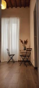 Zimmer mit einem Tisch, 2 Stühlen und einem Fenster in der Unterkunft Il porto di Ale e Kat in Livorno