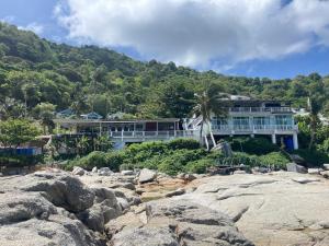 a large house on a hill with rocks at Naiharn On The Rock Resort Phuket in Nai Harn Beach
