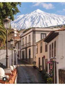 a mountain in the background of a street with buildings at Alojamiento PLAZA CASCO HISTORICO in Icod de los Vinos