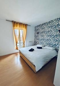 1 dormitorio con cama y ventana grande en Les Mathurins, en Châlons-en-Champagne