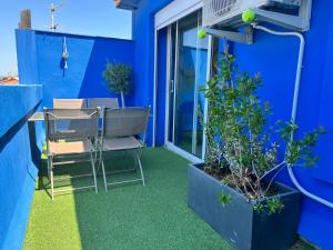 une chambre bleue avec une table, des chaises et des plantes dans l'établissement Roussillon appart avec terrasse, à Perpignan