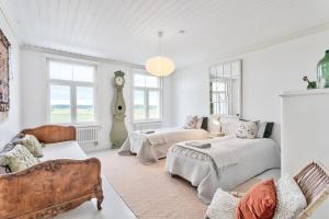 Habitación blanca con 2 camas y sofá en Villa Degerby - 330m2 Lux Manor w/Heated Pool, Spa, en Degerby