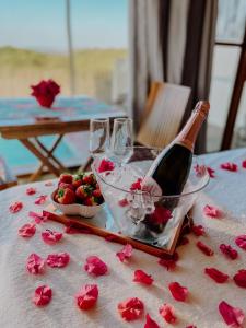 a table with a bottle of wine and some roses at Vila do Alto - Beach Homes in Itarema