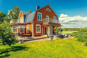 a large red house with a large yard at Villa Degerby - 330m2 Lux Manor w/Heated Pool, Spa in Degerby