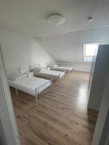 Habitación con 3 camas y suelo de madera. en Kopp, en Lohfelden