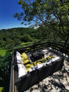 a balcony with pillows and a view of a forest at Greencajt in Jakopovec