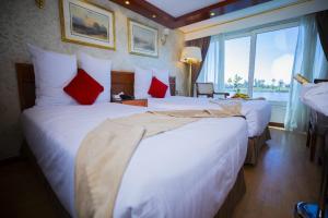 a hotel room with two beds with red pillows at Bule Shadow III in Nag` el-Fuqâhi