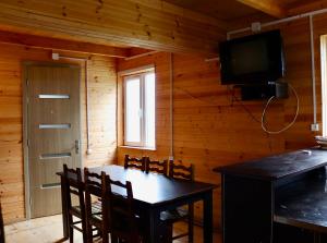 a dining room with a table and chairs and a television at Hillside Bakhmaro in Chʼkhakoura