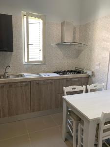 Una cocina con una mesa, un fregadero y una estufa. en La Masseria di Felicetta, en SantʼAnastasia 10 fotos más