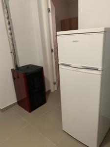 Un refrigerador blanco y un microondas rojo en una habitación. en La Masseria di Felicetta, en SantʼAnastasia