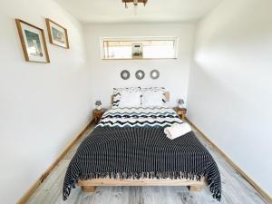 a bedroom with a bed with a black and white comforter at apartament Wigry -domek z altaną na wyłączność in Leszczewek