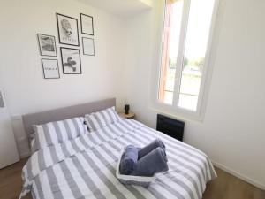 a bedroom with a bed with a pillow on it at LE MEDITERRANEEN *T2 (40m²) *WIFI*PARKING PRIVE* in Lourdes