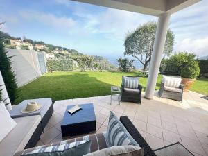 eine Terrasse mit Stühlen, einem Tisch und einer Liegewiese in der Unterkunft Villa whit garden 10mn from Monaco in La Turbie