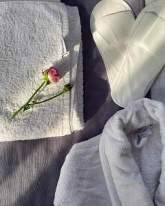 a white towel with a pink rose and a heart at RL Hotel in Stepʼanavan