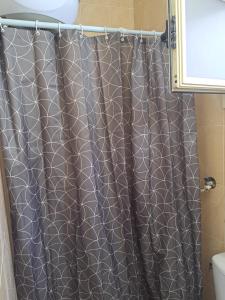 einem Duschvorhang mit grau-weißem Muster in der Unterkunft Sweet Home Flat 1 in Hurghada