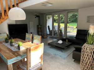 a living room with a couch and a table at Frankenwald Ferienhaus FourStars am See in Lichtenberg, Bayern, Oberfranken, Bad Steben - Hof -Saale, Rennsteig in Lichtenberg