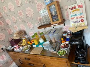 a kitchen counter with food and drinks and a coffee maker at The Palms Guest house in Torquay