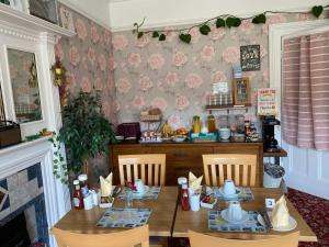 a dining room with a table and chairs and a table and chairs at The Palms Guest house in Torquay