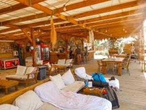 a room with couches and tables and tables and chairs at Ein Gedi Camp Lodge in Ein Gedi