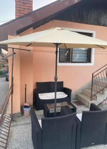 a patio with a table and an umbrella at Mićin dom in Pirot