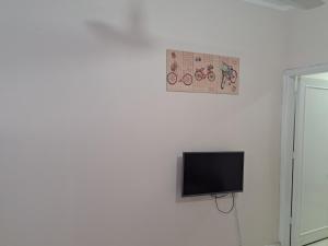 Sweet Home Flat 1 في الغردقة: تلفزيون بشاشة مسطحة معلق على جدار أبيض