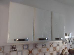 a kitchen with white cabinets with two bowls on them at Apartamento Praia do Janga Paulista Pe in Paulista +4 photos